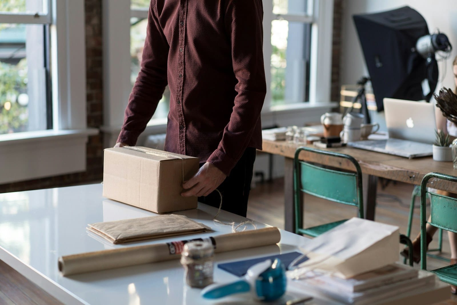 Mesa de trabajo de una tienda online con cajas de envío preparadas y un ordenador portátil